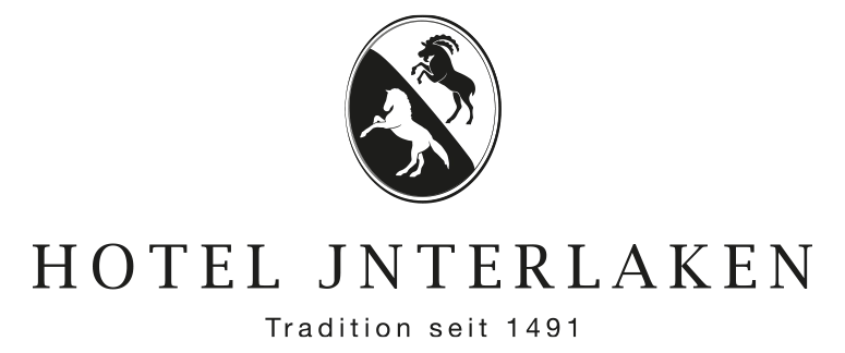 Logo für das Hotel Interlaken mit zwei sich aufbäumenden Pferden, die in entgegengesetzte Richtungen blicken, in einem Oval über dem Text „HOTEL INTERLAKEN“ und „Tradition seit 1491“.